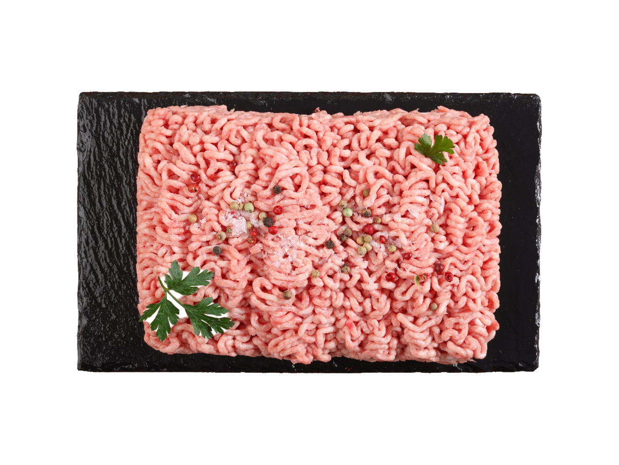Sveže mleveno meso sa začinima i peršunom na crnoj ploči.