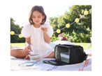 A girl enjoying a picnic with a lunch bag and food containers on a blanket.