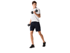 Man in CRIVIT sports shorts and t-shirt, exercising with dumbbells.