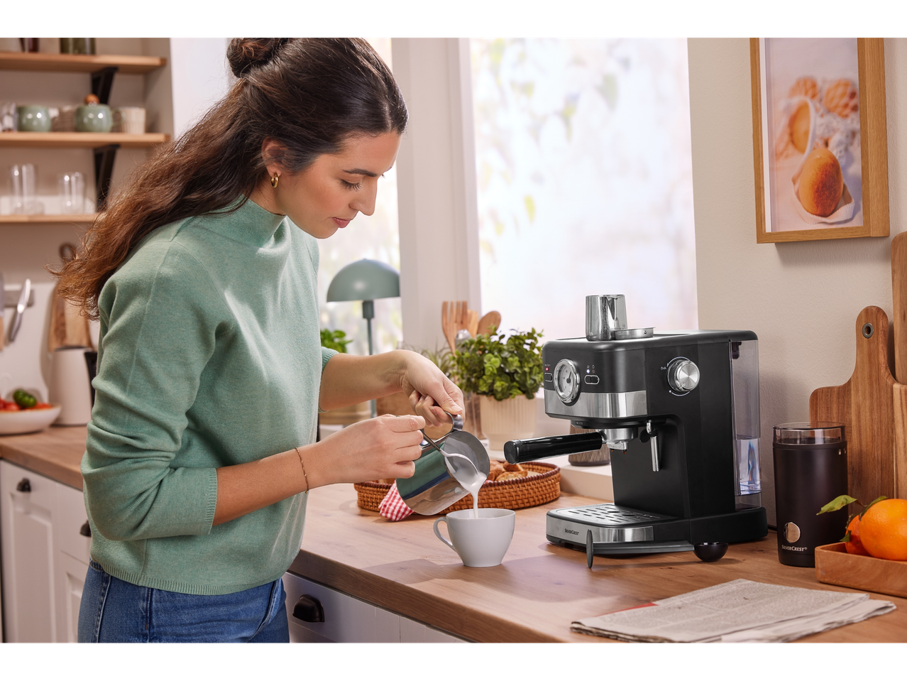Mulher a fazer café com uma máquina SilverCrest numa cozinha moderna.
