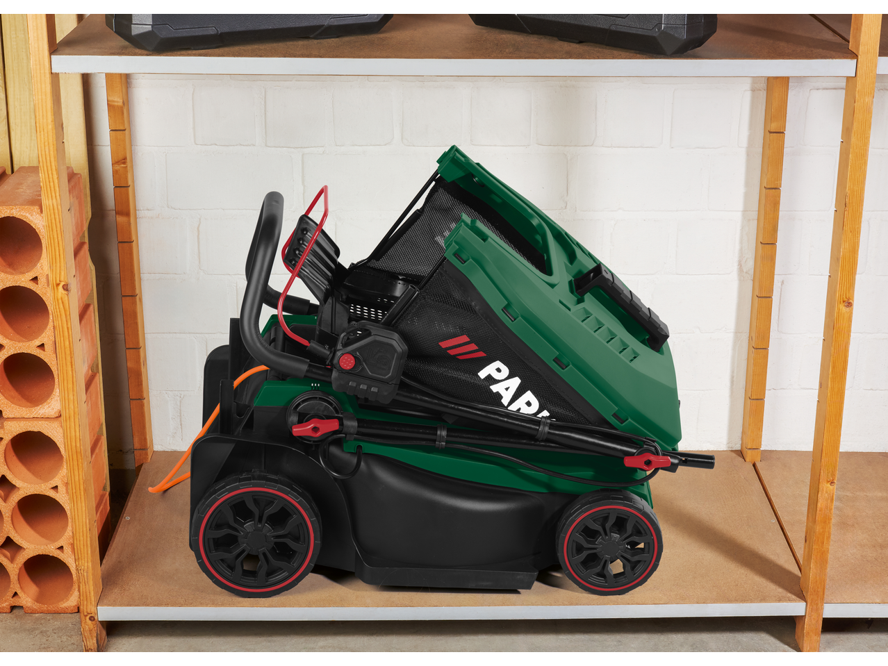 PARKSIDE® 1500W Electric Lawnmower, folded for storage on a shelf.