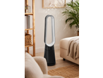 A modern bladeless fan in a cozy living room with a wooden shelf and a sofa.