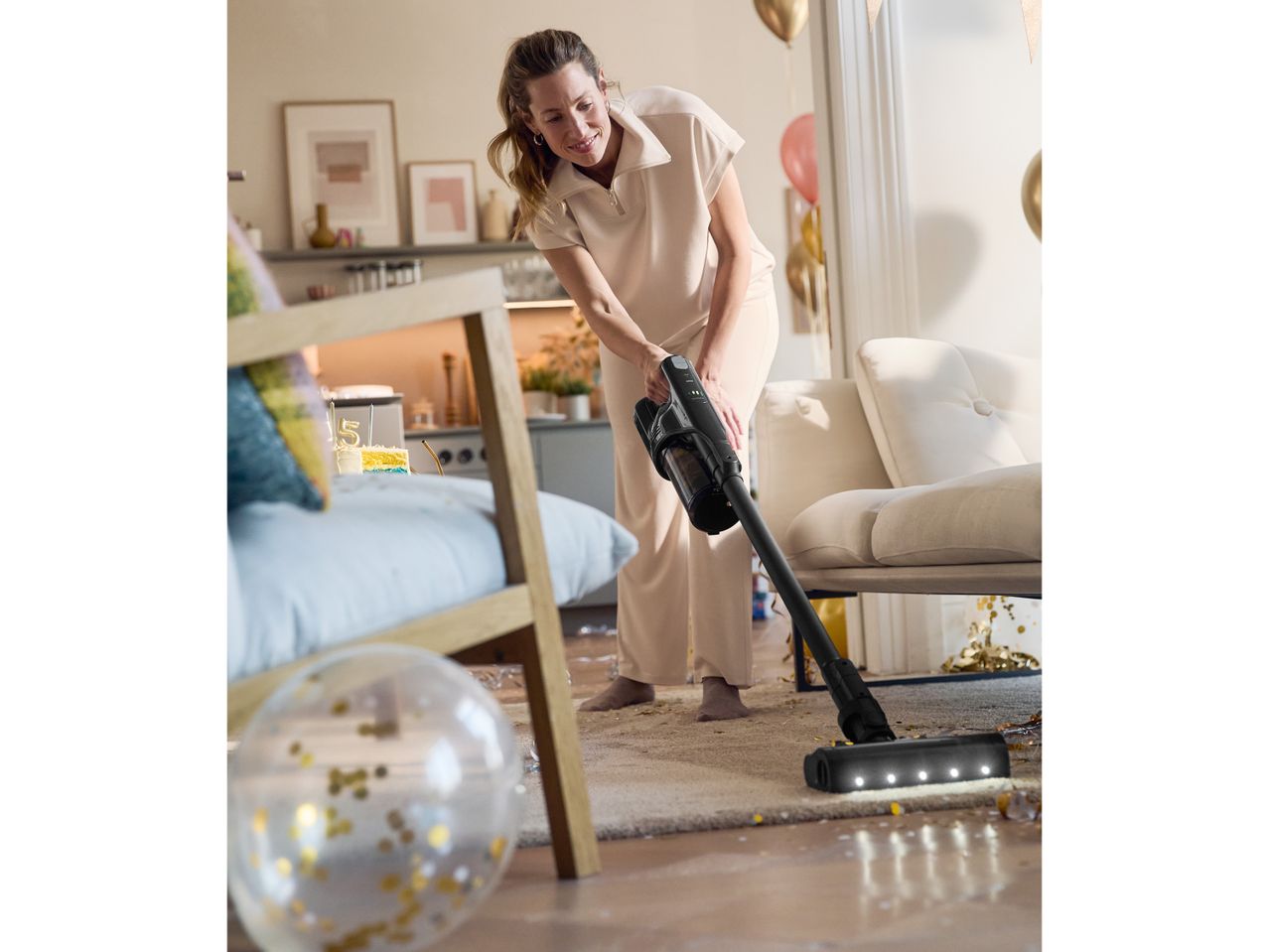 Жена използва безжичен прахосмукачка Dyson за почистване на пода.
