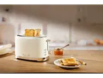 Cream toaster, toast, and jam on a wooden table.