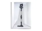 Black and silver cordless stick vacuum cleaner standing upright in a white studio setting.