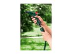 Hands connecting a green garden hose nozzle to a green expandable hose.