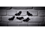 Black bat Halloween decorations on a white brick wall.