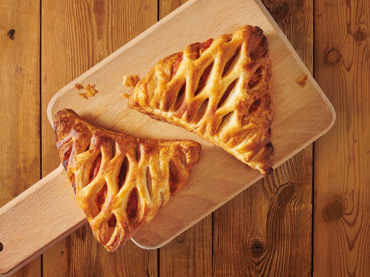 Две сладкиши от бутер тесто върху дървена дъска.