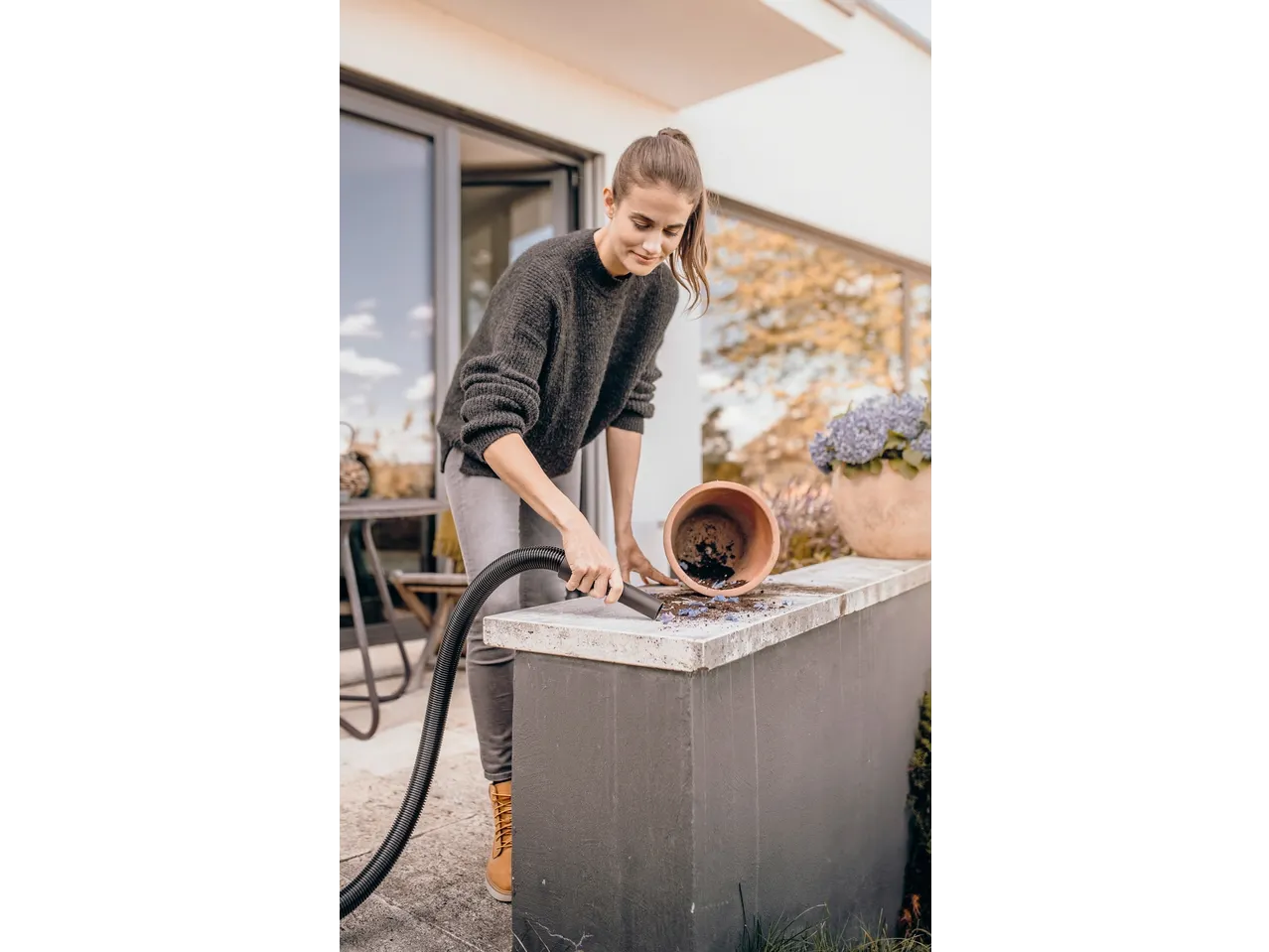 Žena koristi KÄRCHER usisavač za mokro i suho usisavanje za čišćenje zemlje.
