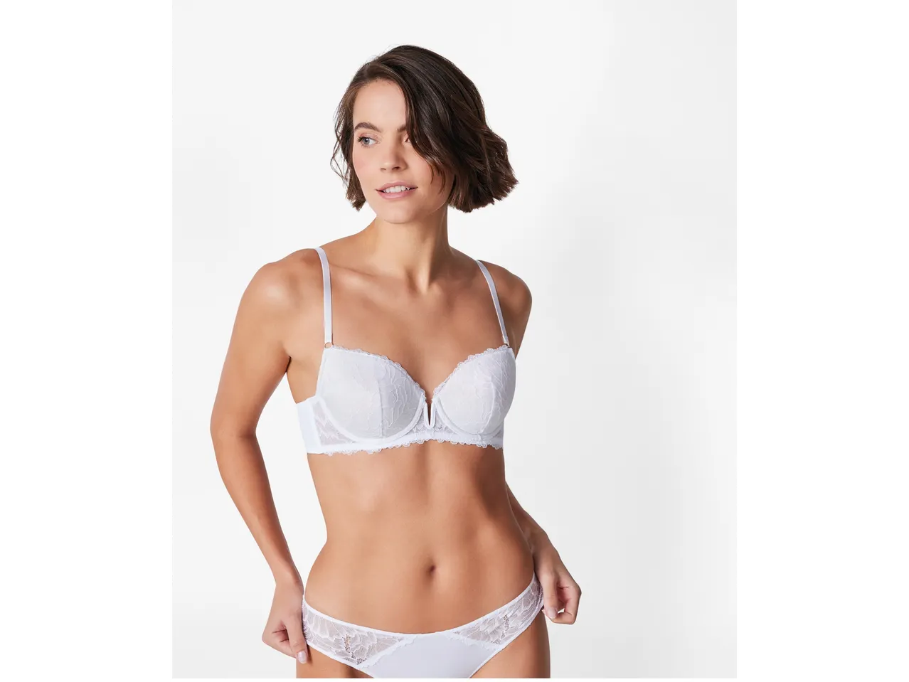 Model purtând un set de lenjerie intimă albă din dantelă.