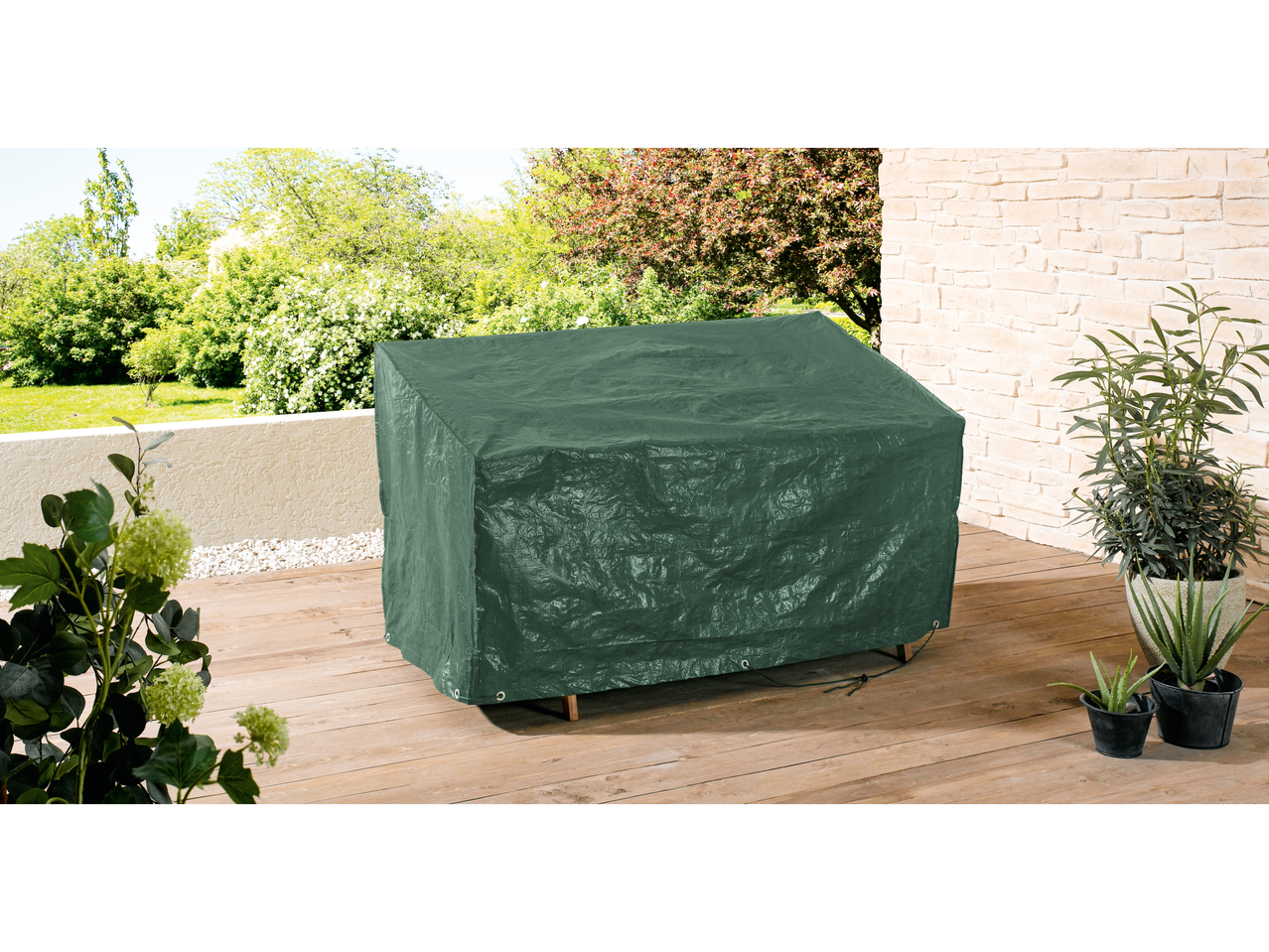 Green protective cover for outdoor furniture on a wooden deck.
