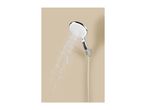 Chrome shower head spraying water against a beige background.