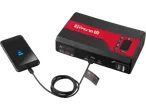 Portable jump starter and power bank charging a smartphone, with 'ULTIMATE SPEED' branding and various ports.