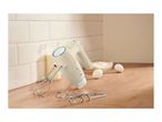 Cream-colored hand mixer with beaters and dough hooks on a wooden kitchen counter