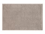 A rectangular beige bath mat with a textured, bobble surface.