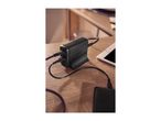 Black multi-port USB charger with cables connected to a tablet and power bank on a wooden table.