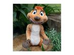 Timon plush toy sitting on a tree stump surrounded by green plants.