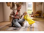 Mulher e cão com capa de chuva amarela e trela automática ZOOFARI, prontos para passear.