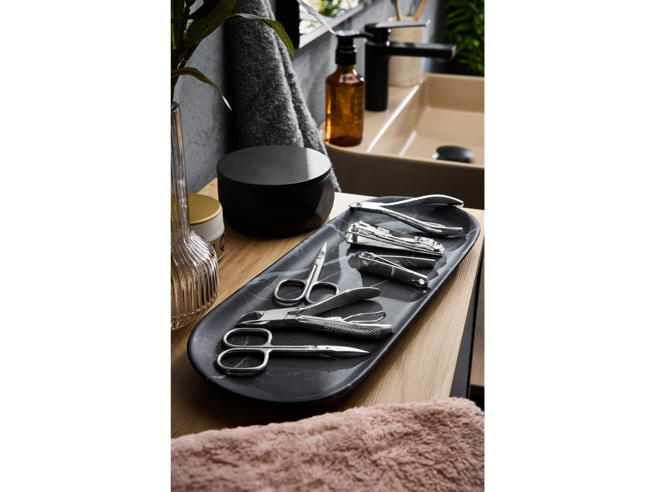 Cien BEAUTY manicure/pedicure accessories on a marble tray next to a sink.