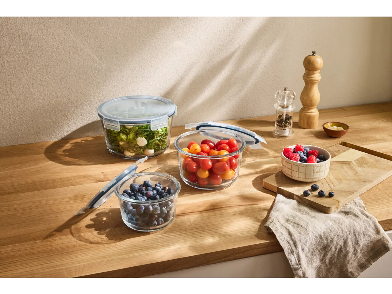 SILVERCREST® Glass Food Storage Containers with salad, tomatoes, and blueberries on a wooden counter.