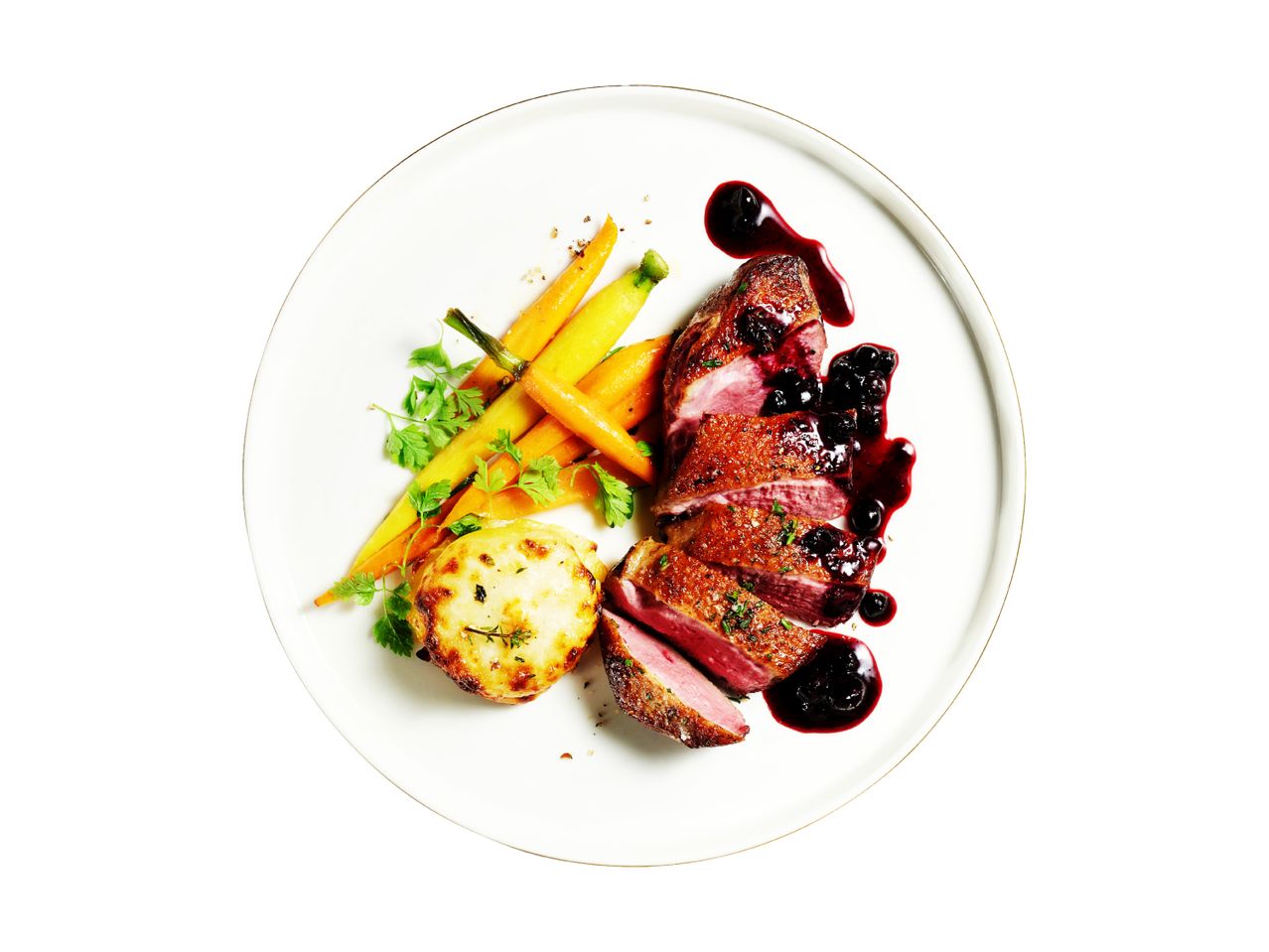 Duck breast with blueberry sauce, roasted carrots, and potato gratin on a white plate.