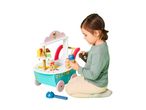 A child playing with a wooden ice cream and sweets stand, holding an ice cream cone.
