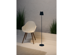 Moderne vloerlamp met stoffen kap, stoel en planten.