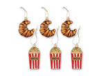 Drei Popcorn- und drei Croissant-Weihnachtsbaumschmuckstücke mit goldenen Aufhängern.