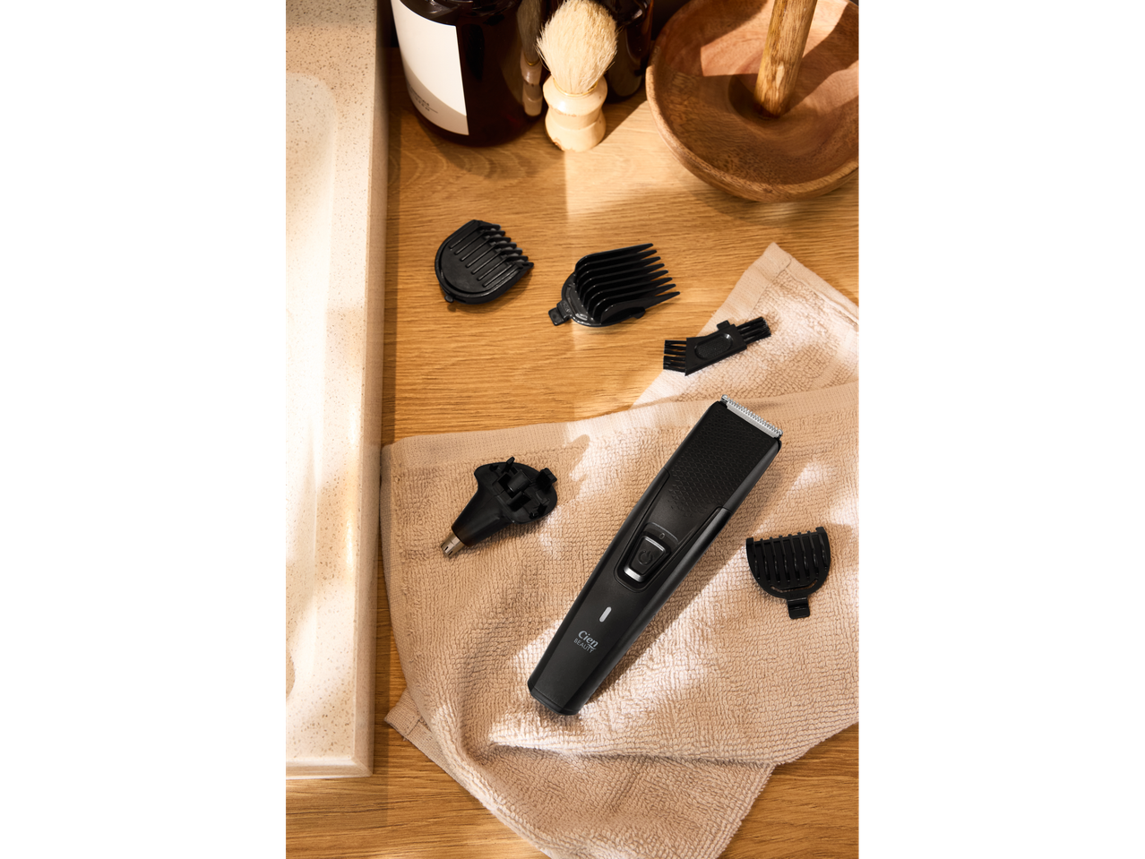 Cien BEAUTY trimer za kosu s dodacima na ručniku, pored umivaonika.