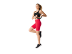 Žena u CRIVIT sportskom grudnjaku i crvenom šortsu, drži Pilates prsten, balansira na jednoj nozi.
