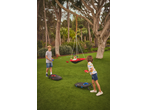 Kids playing bean bag toss on artificial grass, with one child in a swing.