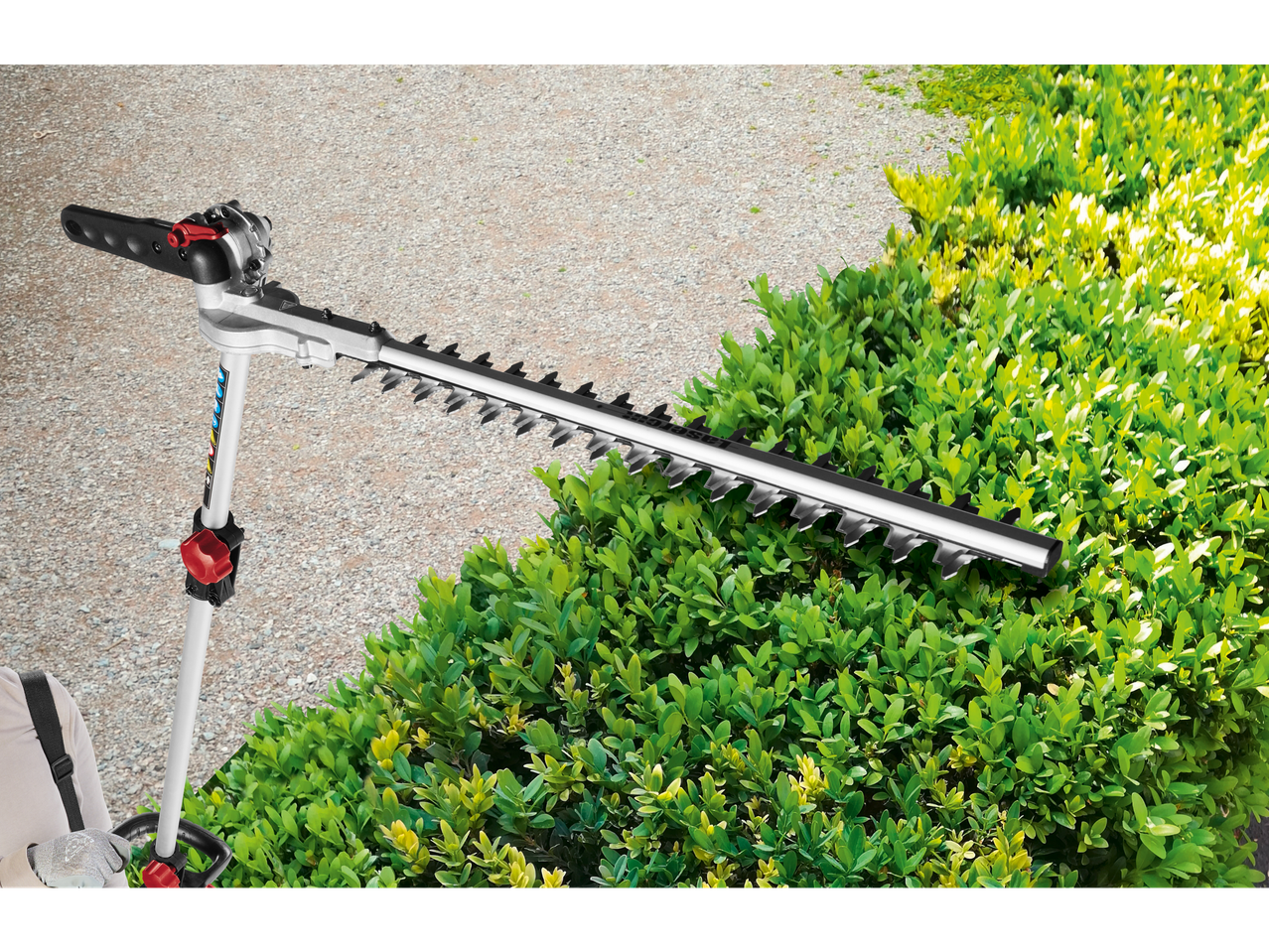 Long-handled hedge trimmer next to a bush.