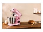 Pink SilverCrest stand mixer with ingredients for baking on a wooden counter.