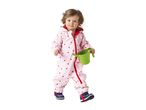 Toddler in a pink heart-patterned waterproof suit holding a green watering can.
