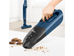 Handheld vacuum cleaning cookie crumbs, with a stick vacuum in the background.
