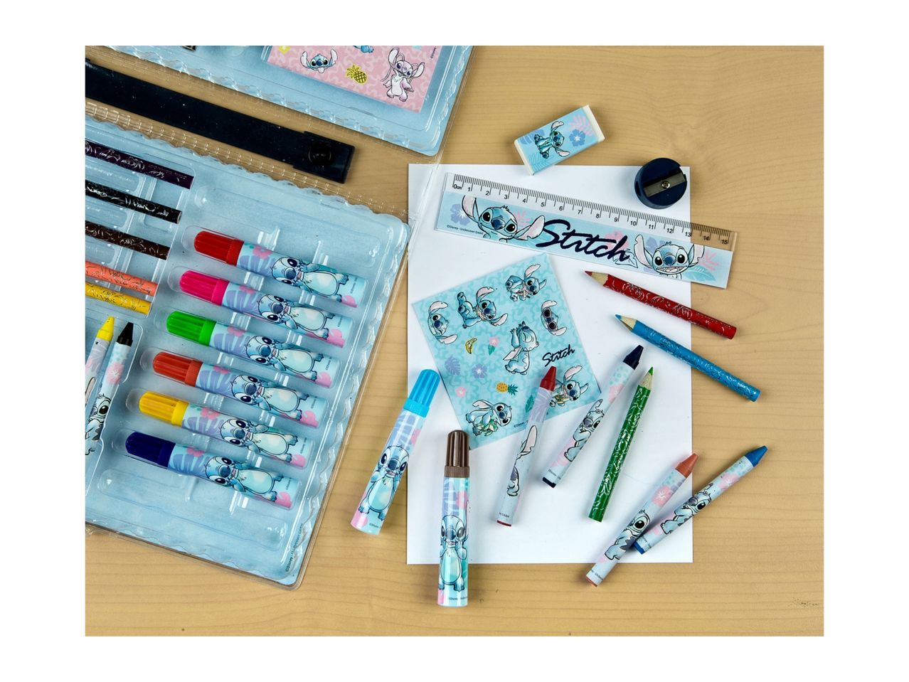 An assortment of art supplies including paints, pencils, and a ruler, neatly arranged on a table.