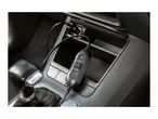 Car interior with a 12V car charger plugged into the cigarette lighter socket.