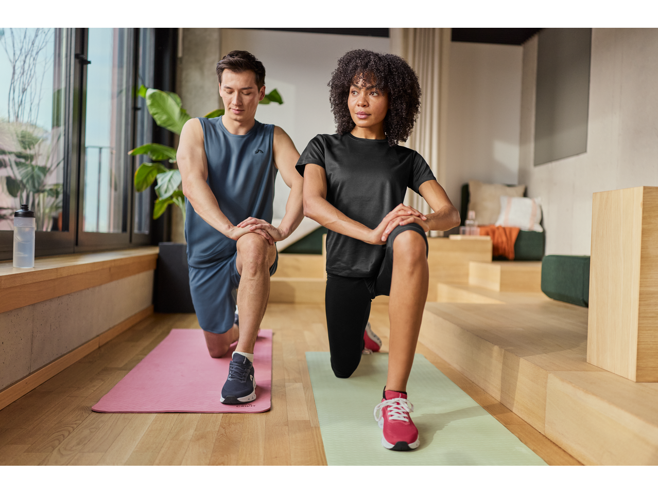 Homem e mulher ajoelhados em tapetes de fitness CRIVIT, a fazer exercícios.
