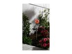 Solar garden stake light with a cracked glass globe, surrounded by plants and flowers.