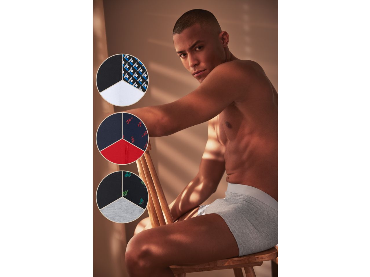 Un uomo in boxer grigi, con tre campioni circolari di tessuti per intimo con diversi motivi.