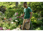 Man watering garden with Parkside Performance Multifunction Spray Gun and garden hose.