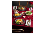 A romantic dinner with steak, potato gratin, green vegetables, macarons, and red roses.