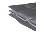 A cutaway view of a mattress showing layers of grey fabric and blue gel beads.