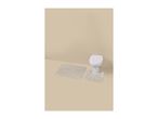 Bathroom with a white toilet and two beige striped bath mats on a light brown floor.