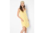 Woman in a yellow summer dress and a patterned headscarf, smiling brightly.