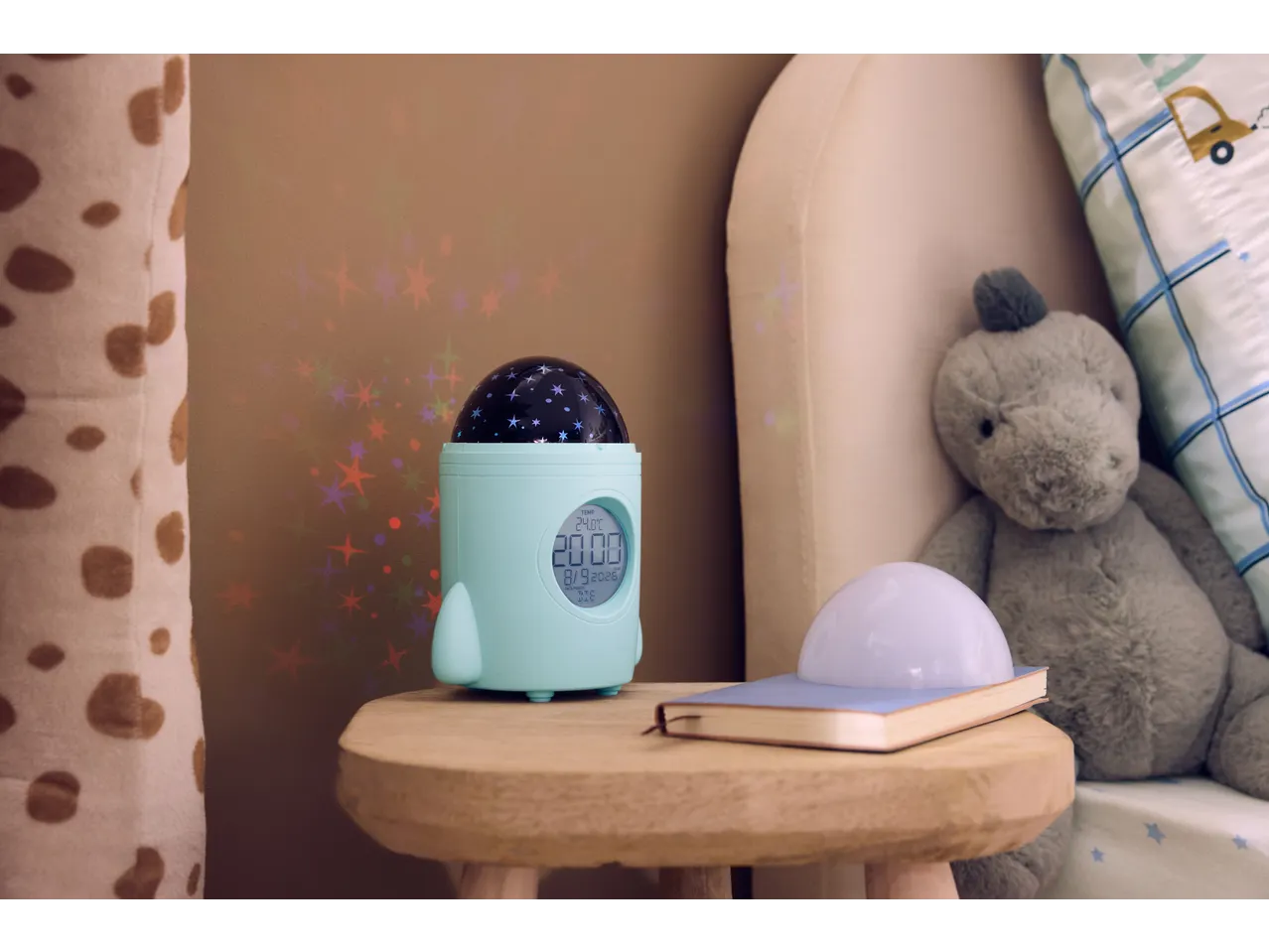 Despertador infantil TRONIC em forma de foguete com projetor de estrelas na mesa de cabeceira.