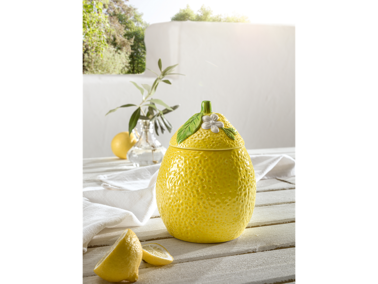 Récipient en céramique en forme de citron et tranches de citron.