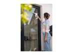 Woman cleaning a window with a window vacuum cleaner.