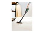 Cordless handheld vacuum cleaner cleaning up dirt on a workshop floor.
