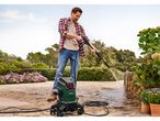 A man uses a PARKSIDE® Flexi Pressure Washer to clean a patio.